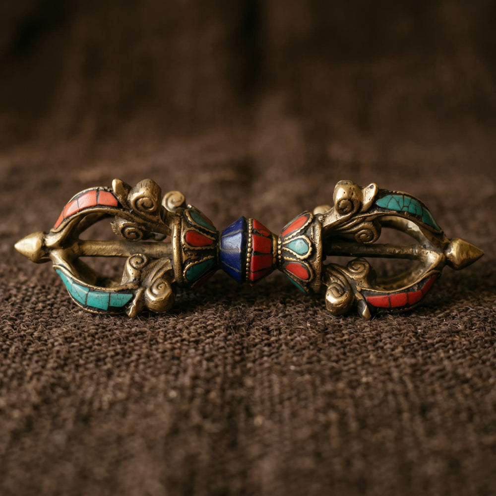 Side view of the vajra showing both open prong cages with red and blue-green inlay strips, two lotus cups and the deep blue and red center grip