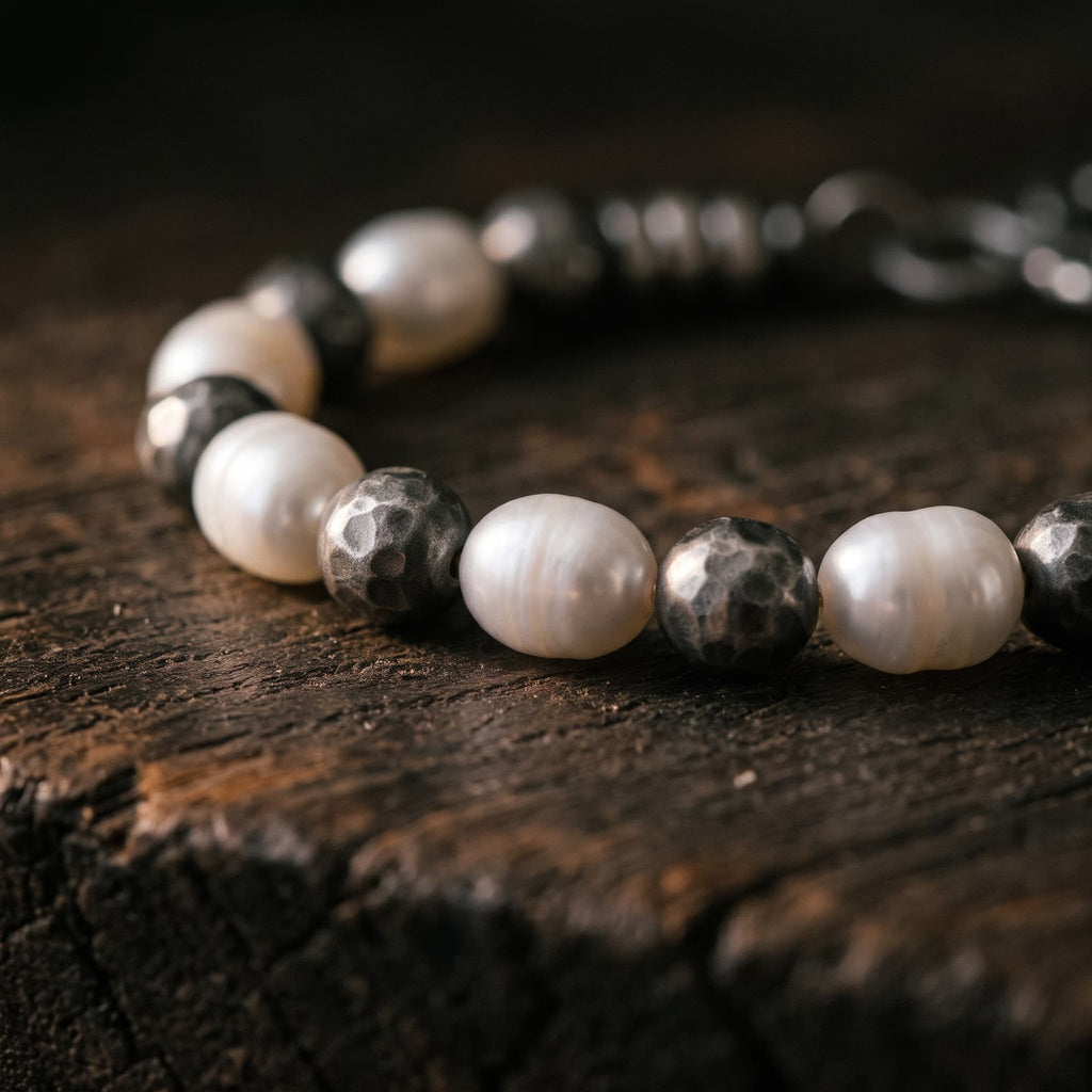 Close-up of white pearls and round hammered silver beads with a darkened finish, every hammer mark visible