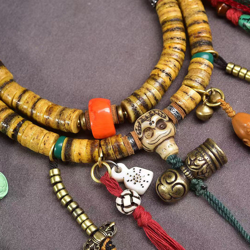 Supplier close-up of the striped bone disc mala with skull guru bead, orange bead and hanging charms