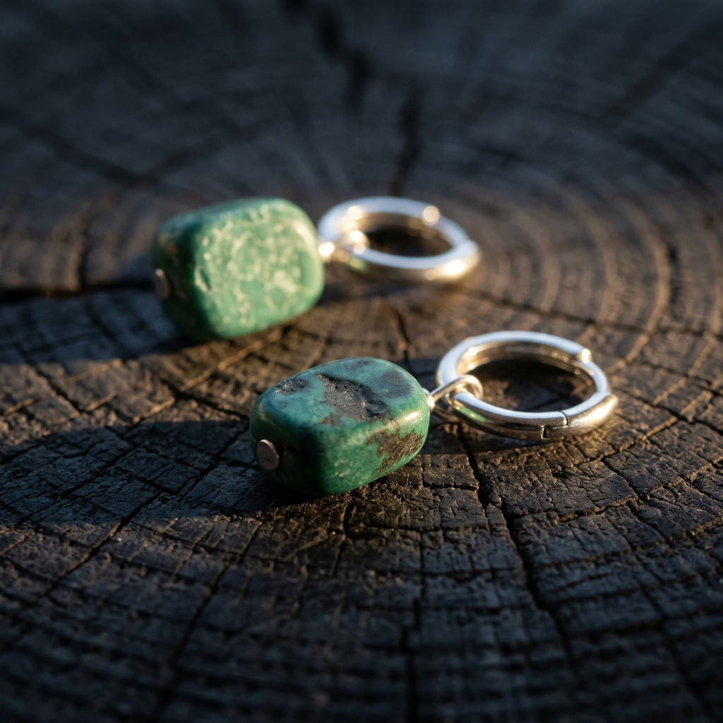 Side view of a green stone hoop earring showing the stone's thickness and the hoop hinge