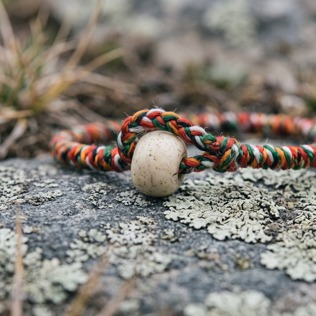Close-up of the braided cord loop hooked over the white ox bone button bead