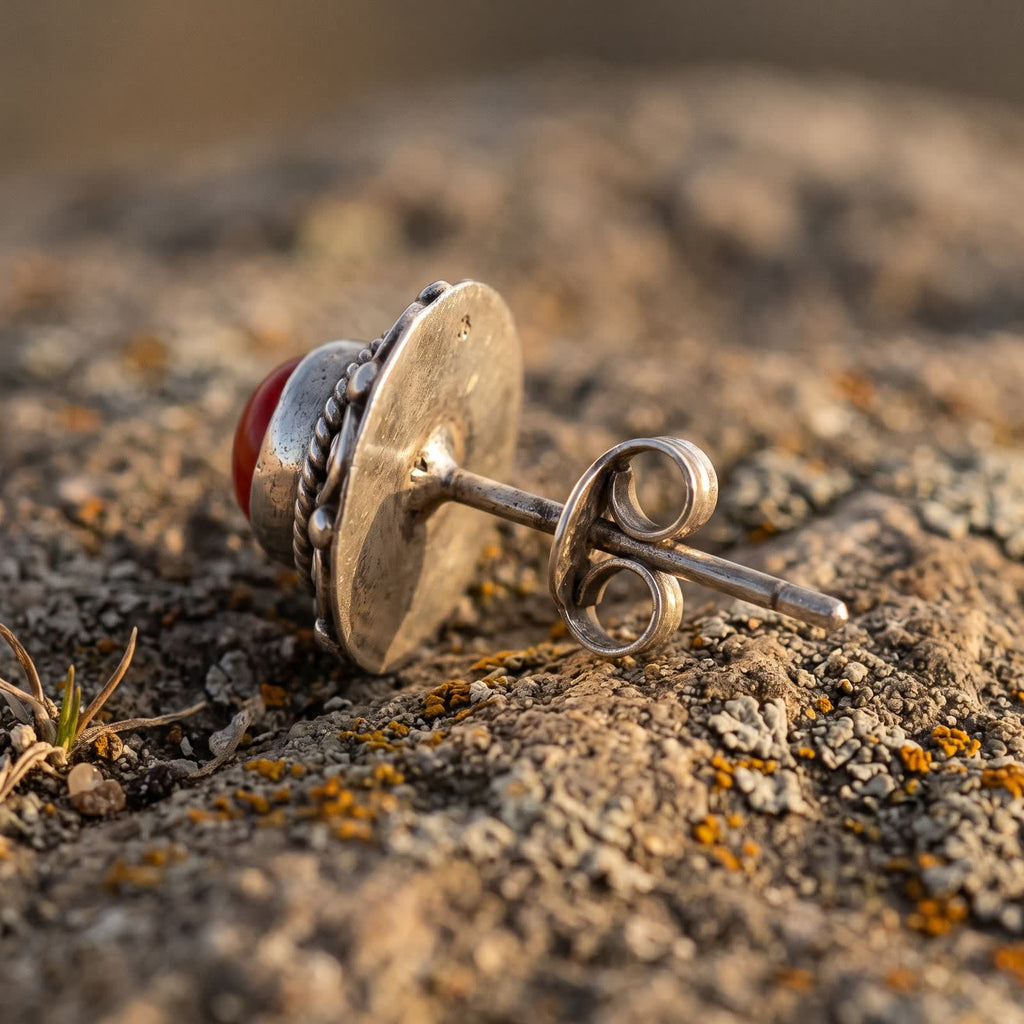 Side view of one stud earring showing the flat back, the post and the butterfly back behind the red stone