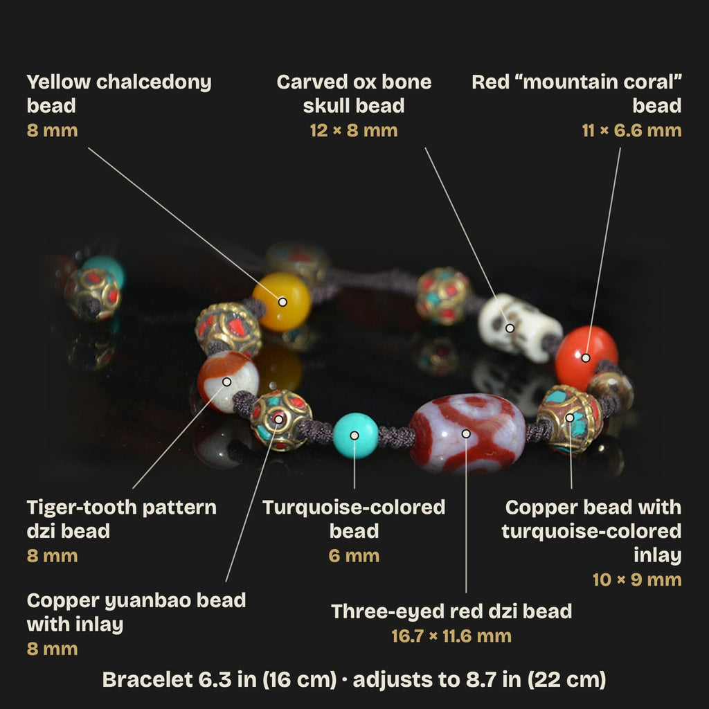 Labeled bead guide: three-eyed red dzi 16.7 × 11.6 mm, tiger-tooth pattern dzi 8 mm, carved ox bone skull bead 12 × 8 mm, red bead 11 × 6.6 mm, copper beads with inlay, blue-green bead 6 mm, yellow chalcedony bead 8 mm; bracelet 6.3 in (16 cm), adjusts to 8.7 in (22 cm)