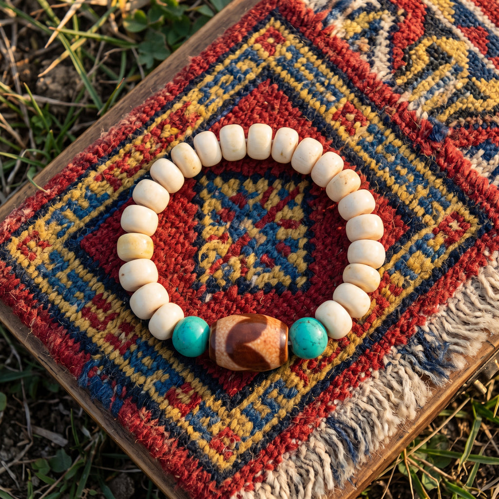 Cream bone bead bracelet with turquoise and a brown patterned bead on a red, yellow and blue rug