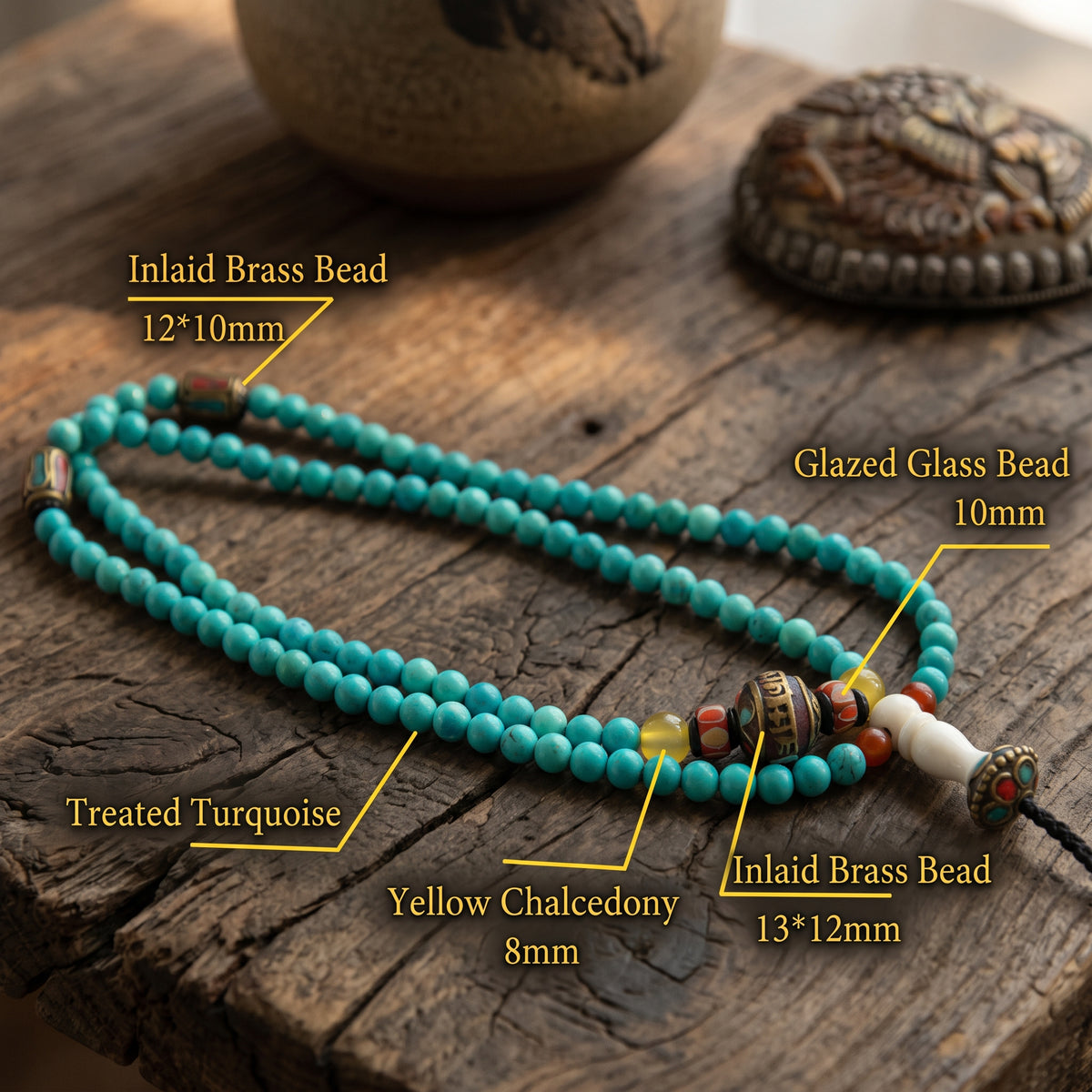 Labeled turquoise mala on old wood: stabilized turquoise, inlaid brass beads, glazed glass bead, yellow chalcedony