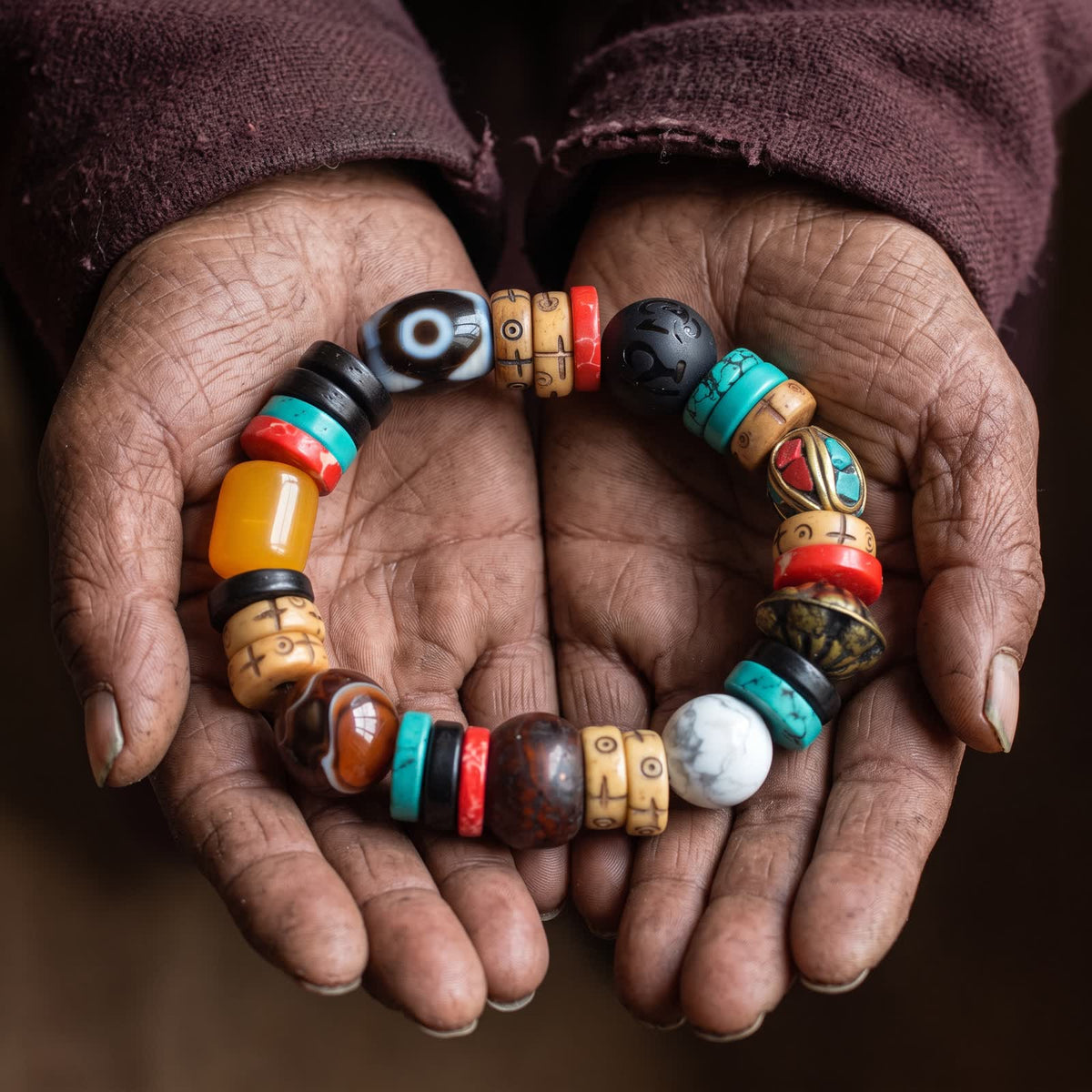 Elderly weathered hands holding the dzi and yak bone bracelet in cupped palms