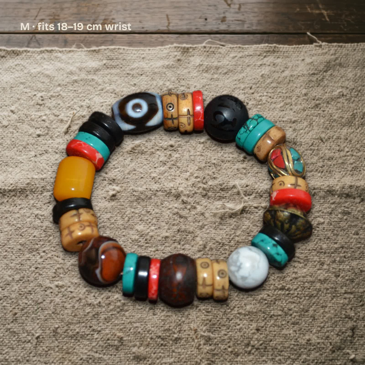 Size M dzi and carved yak bone bracelet on undyed wool, labelled fits 18–19 cm wrist