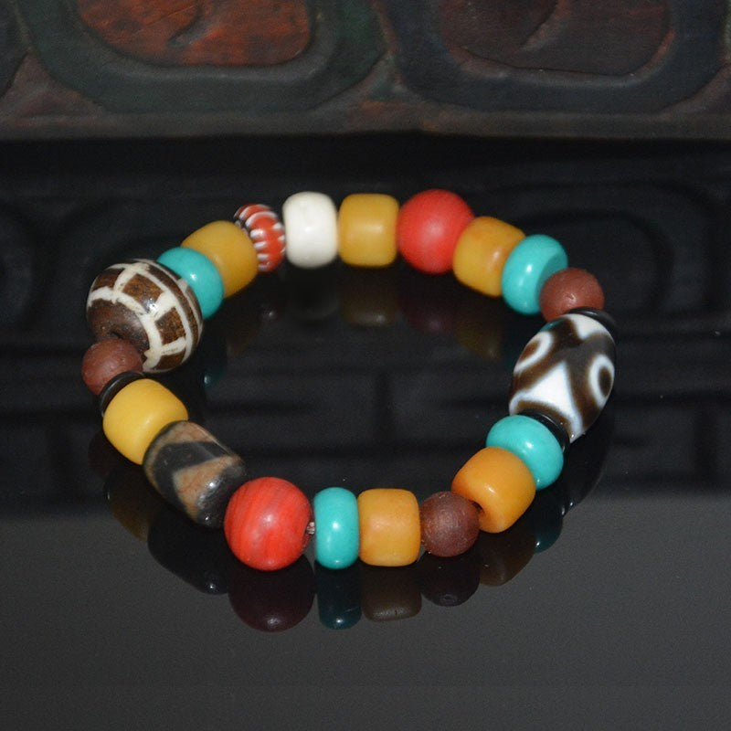 Supplier photo of the multi-bead bracelet on a carved wooden background