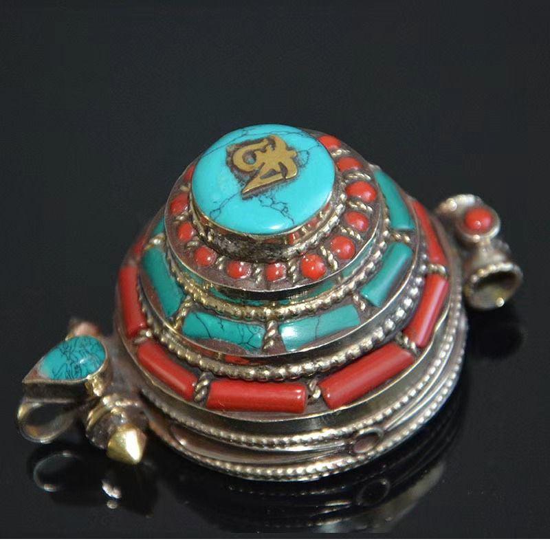 Real photo of the tiered Om gau box pendant with stabilized turquoise and red stone inlay