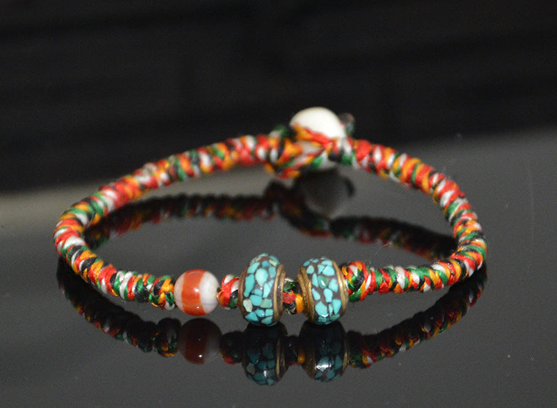 Supplier photo of the five-color cord bracelet on a dark background