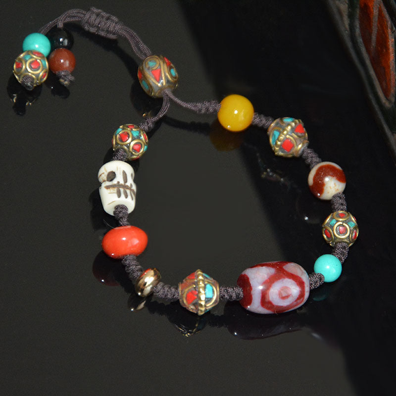 Supplier photo of the red three-eyed dzi braided-cord bracelet, top view
